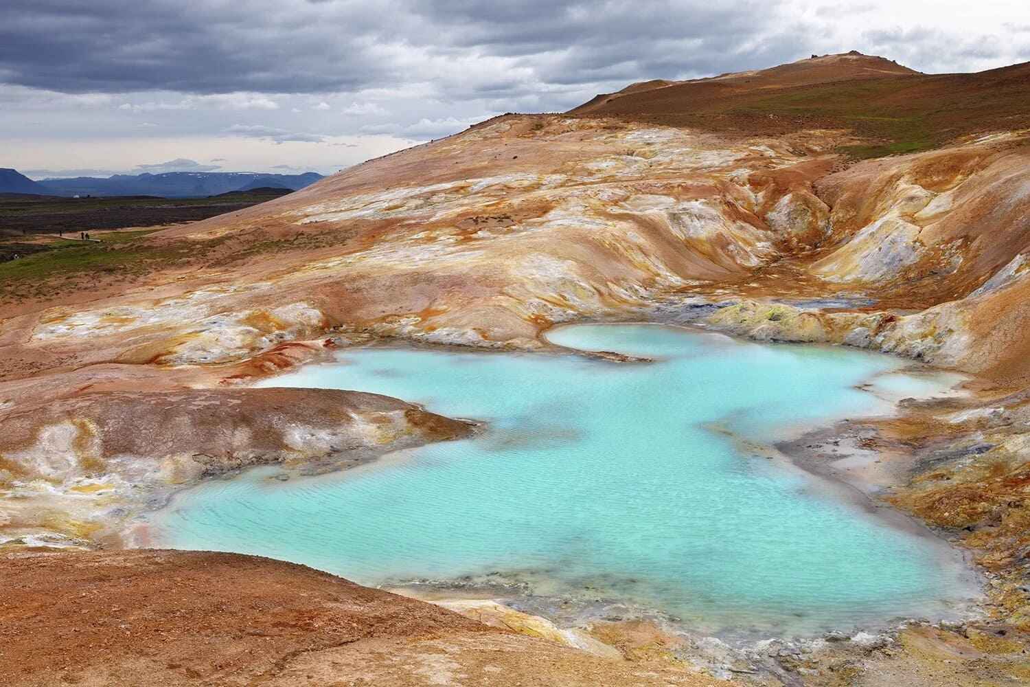 Secluded natural geothermal hot spring pool in Iceland surrounded by mossy lava rock and steam rising into cool mountain air, intimate wellness honeymoon experience, editorial photography