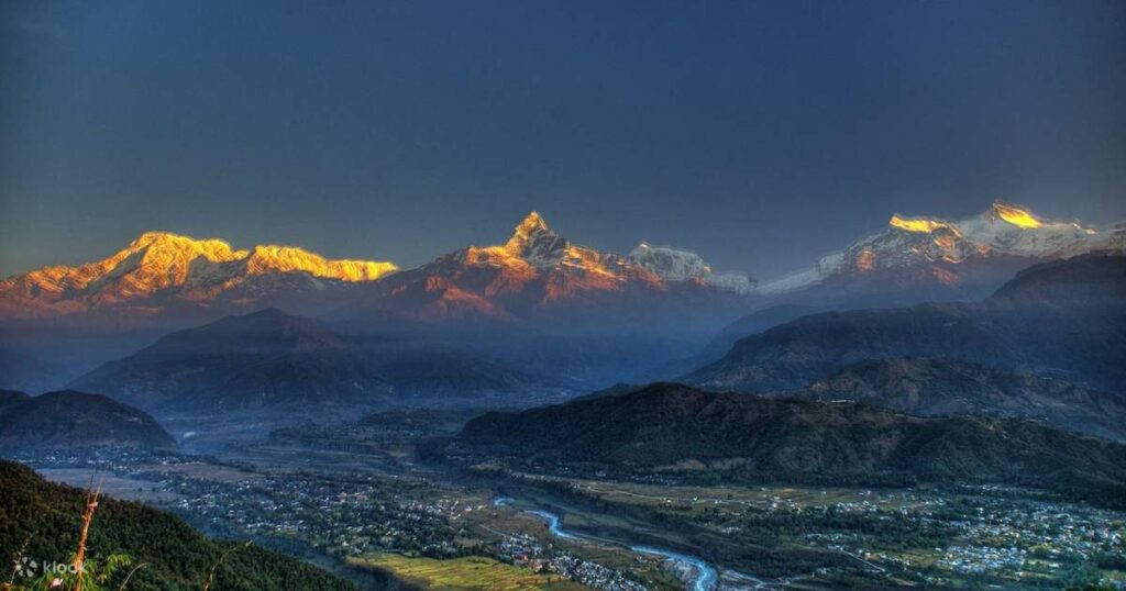 Panoramic view of Annapurna mountain range from Sarangkot viewpoint near Pokhara Nepal with golden sunrise light on snow-capp