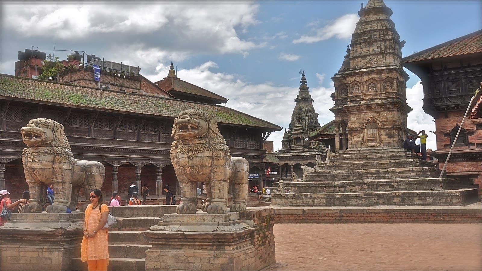 Ancient Durbar Square in Bhaktapur Nepal with intricately carved wooden temples and pagodas under warm golden light with Himalayan foothills in the background, heritage honeymoon destination, editorial photography