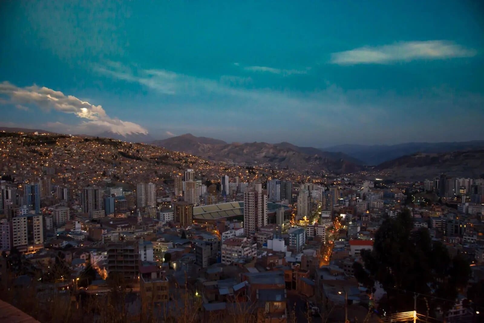 Panoramic view of La Paz Bolivia built into a steep canyon with colourful buildings cascading down the hillsides and snow-capped Illimani peak visible behind, high altitude honeymoon city, editorial photography
