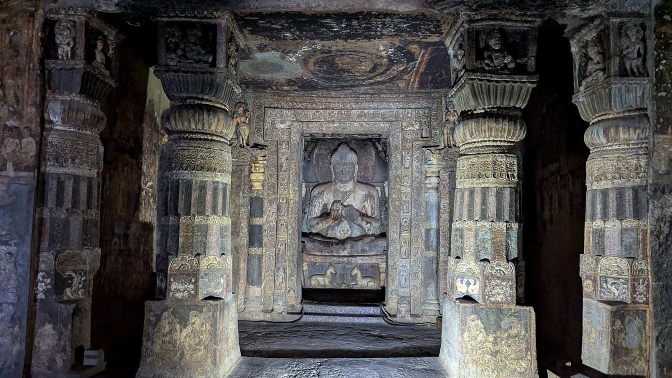 Ancient temple interior with intricate stone carvings and warm light filtering through arched openings, cultural heritage honeymoon atmosphere, editorial travel photography