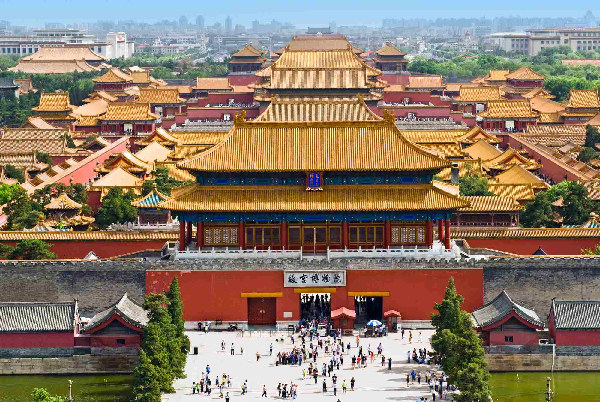 The Forbidden City in Beijing viewed from above with golden rooftops stretching toward the horizon under clear sky, imperial Chinese heritage honeymoon, editorial travel photography