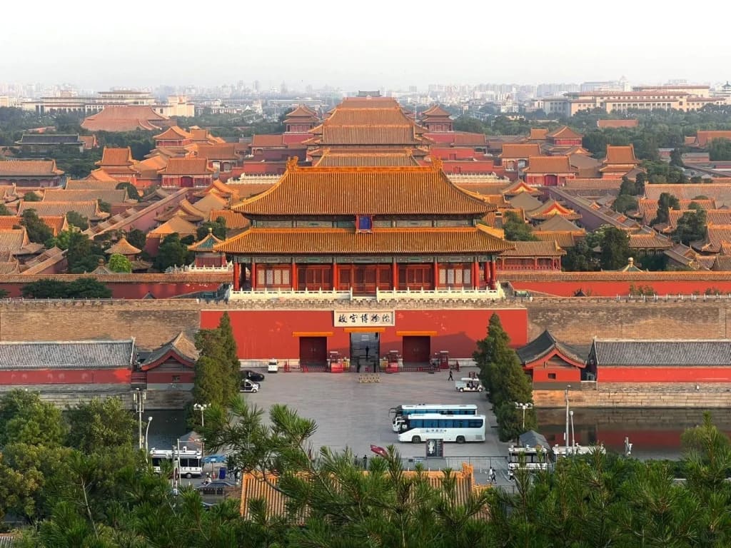 Forbidden City golden rooftops at dawn with empty marble courtyards stretching toward distant gates, soft morning light reflecting off imperial tiles, Beijing honeymoon, editorial travel photography