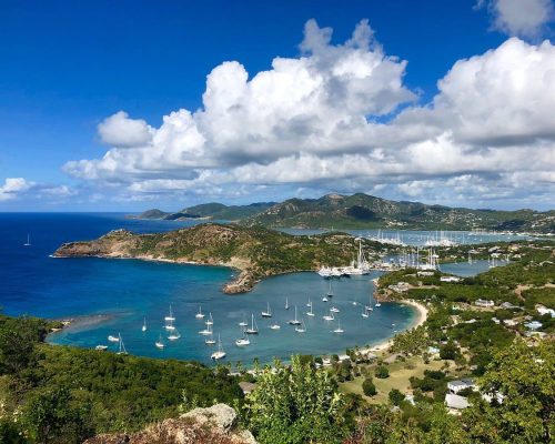 Aerial view of English Harbour Antigua with historic Nelson's Dockyard and sailing yachts moored in turquoise Caribbean water