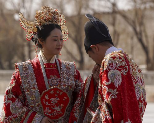 Una pareja china se toma fotografías tras contraer matrimonio este sábado, 15 de febrero, ante la Ciudad Prohibida de Pekín, situada junto a la céntrica y conocida Plaza de Tiananmen. EFE/Lorena Cantó